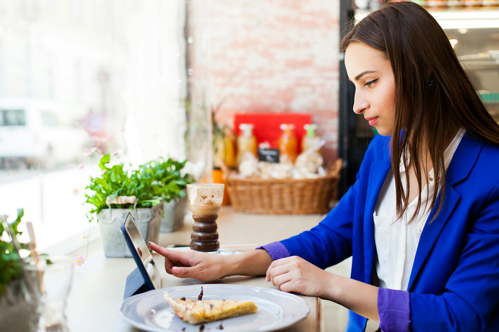 Woman working with a tablet on a table in a cafe 