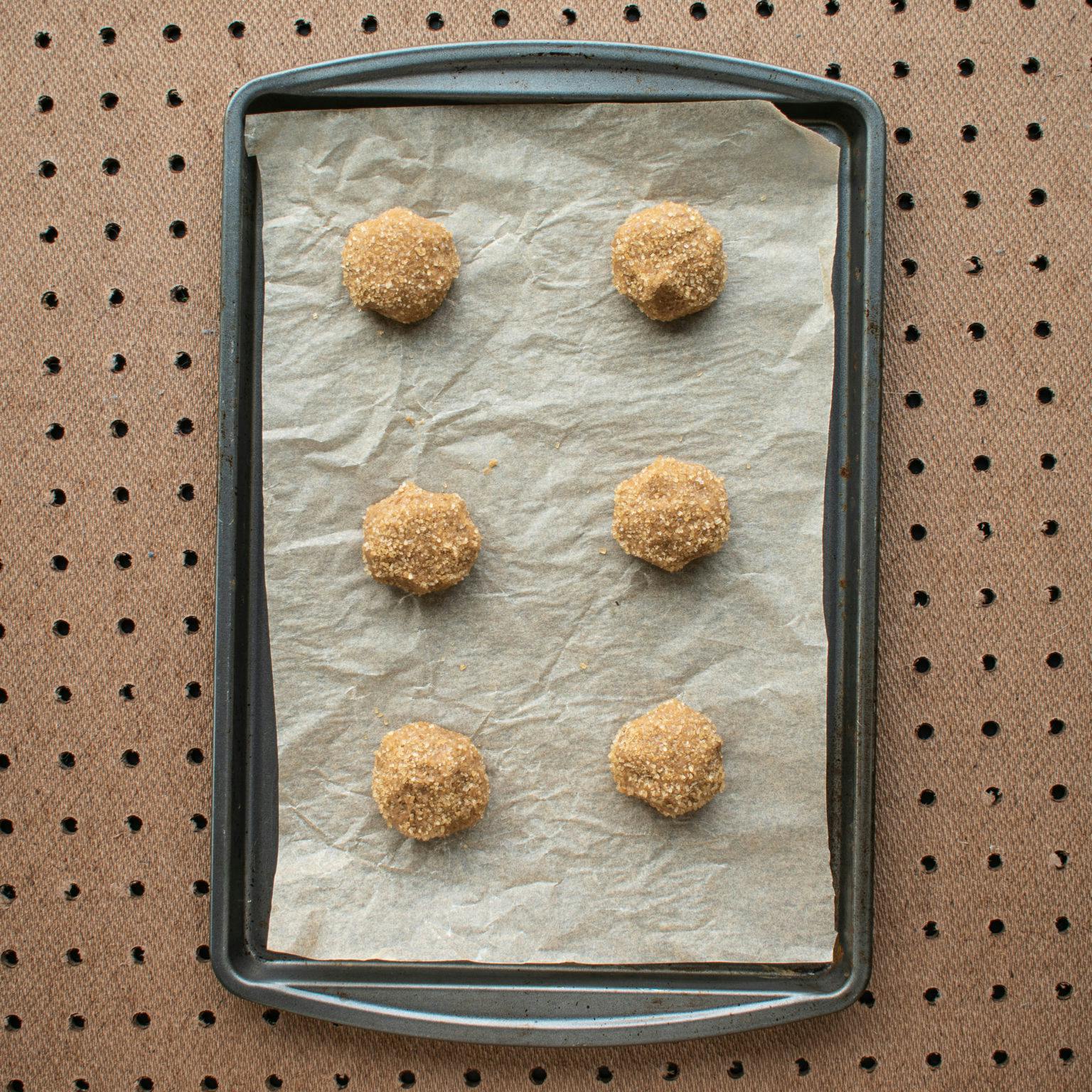 Roll balls of dough in sugar and bake